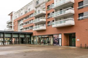 a large red brick building with a store front at Appartement climatisé 3 étoiles T3 chic à Strasbourg avec billard et terrasse in Strasbourg