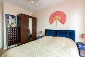 a bedroom with a large bed and a large umbrella on the wall at Appartement climatisé 3 étoiles T3 chic à Strasbourg avec billard et terrasse in Strasbourg