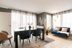 uma sala de estar com uma mesa e cadeiras e um sofá em Appartement climatisé T3 chic à Strasbourg avec billard et terrasse em Estrasburgo