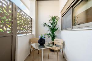 a small table and chairs in a room with a window at Iasmos Luxury Apartment in Heraklio