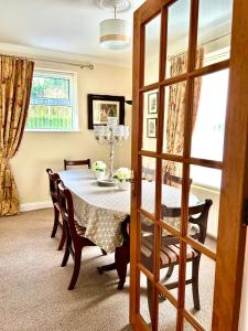 a dining room with a table and chairs and a window at Lime Tree House in Maguires Bridge