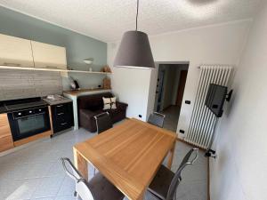 cocina y comedor con mesa de madera y sillas en Pippi Home, en Castello di Fiemme