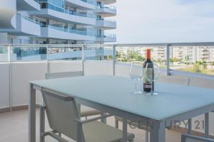 una mesa con una botella de vino y dos copas en Apartamento de lujo con 2 habitaciones en Canet d'en Berenguer, en Canet de Berenguer