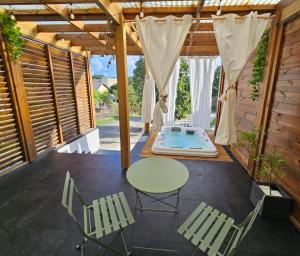een patio met een tafel en stoelen en een bad bij ECOLODGY Suites Villa in Ducos