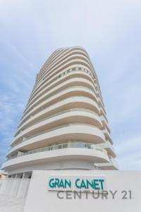 ein hohes Gebäude mit einem Schild davor in der Unterkunft Apartamento de lujo con 2 habitaciones en Canet d'en Berenguer in Canet d'en Berenguer