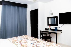 una camera con letto, scrivania e TV di Maxihotel Business Class Culiacan a Culiacán