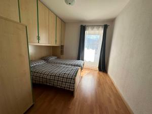two beds in a small room with a window at Pippi Home in Castello di Fiemme