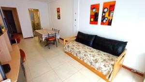 un salon avec un canapé et une table dans l'établissement EfDepartamentos Plaza Colon con balcón a la calle, à Mar del Plata