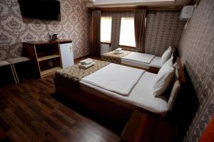Hotel Plaza 777 في سمرقند: غرفه فندقيه سريرين وتلفزيون