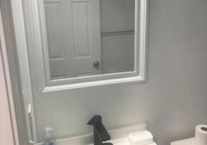 a bathroom with a mirror and a sink at Airport Xpress Guestrooms in Philadelphia