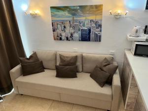 un divano in soggiorno con un dipinto sul muro di Aircon Pool View Nr Yumbo a Playa del Ingles