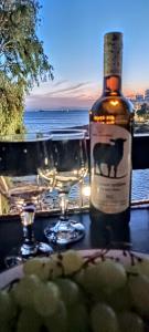 uma garrafa de vinho sentada numa mesa com copos em Sea Luxury Apartments em Piraeus