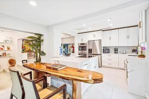 een keuken met een houten tafel en witte kasten bij Coconut Grove, Miami FL in Miami