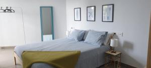 a white bedroom with a large bed with blue pillows at Casa Calafat in Calafat