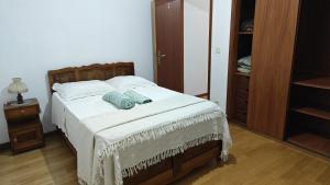a bedroom with a bed with white sheets and blue pillows at AL Sr Domingos in Vila Verde