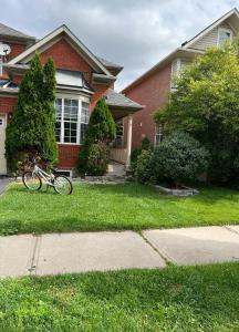 een fiets geparkeerd in het gras voor een huis bij Cozy 1 BR basement apartment with Free Street Parking & Separate Entrance in Milton