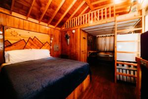 1 dormitorio con 1 cama en una habitación de madera en La Junta Colorado Cabins, en La Junta