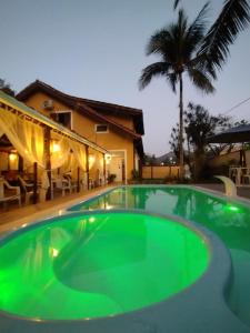 a large swimming pool in a house with a palm tree at Vale do Pontal Angra in Angra dos Reis