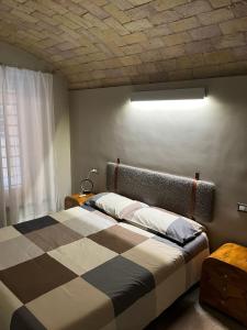 een slaapkamer met een bed met een geruite deken bij The shelter in Rome
