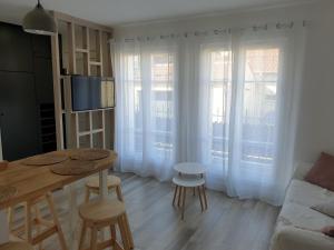 ein Wohnzimmer mit einem Tisch, Stühlen und einem Sofa in der Unterkunft cosy appartment - Clamart Percy Paris in Clamart