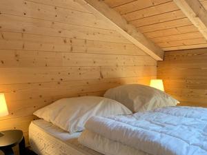 2 Betten in einem Zimmer mit Holzwänden in der Unterkunft Appartement Huez, 2 pièces, 5 personnes - FR-1-405-217 in Huez