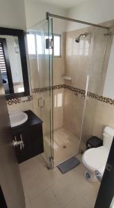 een badkamer met een douche, een toilet en een wastafel bij Moderna casa con piscina y cerca de la playa in Manta