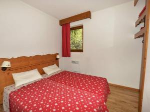 ein Schlafzimmer mit einem Bett mit einer roten Bettdecke und einem Fenster in der Unterkunft Appartement Chamrousse, 3 pièces, 6 personnes - FR-1-549-78 in Chamrousse