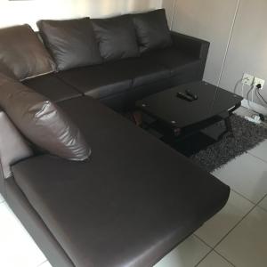 un sofá de cuero negro y una mesa de centro en una habitación en Sandton Accomodation Hydro Park, en Johannesburgo