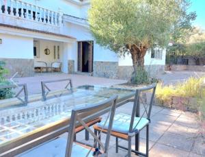a pair of chairs sitting on a glass table on a patio at VILLAJARAS in Córdoba