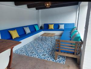 a blue couch with a table and a bench at VILLAJARAS in Córdoba