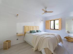 a white bedroom with a bed and a ceiling fan at Apartamento Primera Línea de Playa in San Bartolomé de Tirajana +22 photos