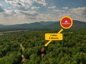 an overhead view of a forest of trees with a yellow sign at Ski Chalet 6 min to Sunday River - Hot Tub, Home Theater, Game Room, Fire Pit - Sleeps 12 in Bethel