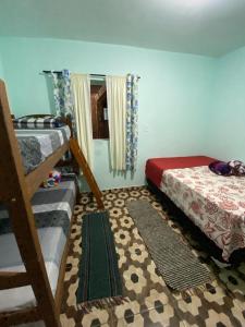 a bedroom with two bunk beds and a rug at Kitnet Centro in São Thomé das Letras