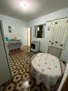 a bedroom with a bed and a table in it at Kitnet Centro in São Thomé das Letras
