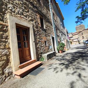 een stenen gebouw met een houten deur en een straat bij La grotta dei nonni in Sassa