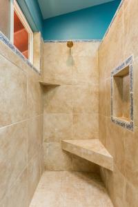 a bathroom with a shower with a bench in it at Hawaiian Asian Vacation House in Pahoa