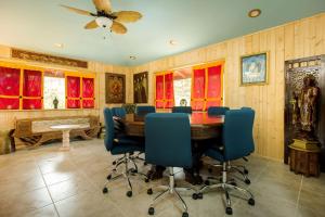 a dining room with a table and blue chairs at Hawaiian Asian Vacation House in Pahoa