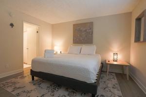 a bedroom with a bed and a table with a lamp at Shabby Chic Oceanside King & 2 Queen bed Pool GYM in Oceanside