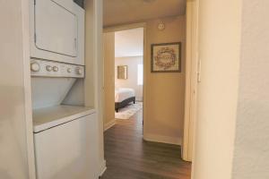 a hallway with a room with a bed and a stove at Shabby Chic Oceanside King & 2 Queen bed Pool GYM in Oceanside +29 photos