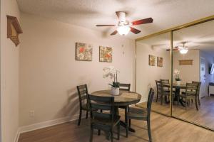 a dining room with a table and chairs and a ceiling fan at Shabby Chic Oceanside King & 2 Queen bed Pool GYM in Oceanside