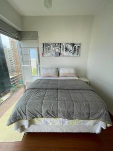 1 dormitorio con cama grande y ventana grande en Departamento Family, en Lima