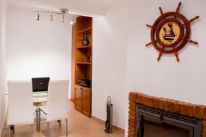 a living room with a fireplace and a table and chairs at Stork Hostel in Olhão