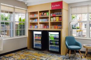 un distributore di bevande con due frigoriferi e una sedia blu di TownePlace Suites Philadelphia Horsham a Horsham
