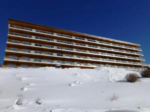 ein großes Gebäude im Schnee mit Schneefußabdrücken in der Unterkunft Appartement Huez, 1 pièce, 4 personnes - FR-1-405-222 in Huez
