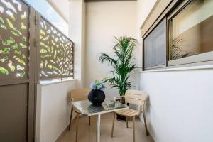 stół i krzesła z wazonem na górze w obiekcie Euphoria Luxury Apartment w Heraklionie
