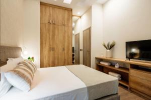 sypialnia z dużym łóżkiem i telewizorem w obiekcie Euphoria Luxury Apartment w Heraklionie