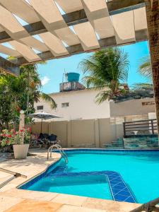 een buitenzwembad met een patio en een zwembad bij Falésia Praia Hotel in Canoa Quebrada