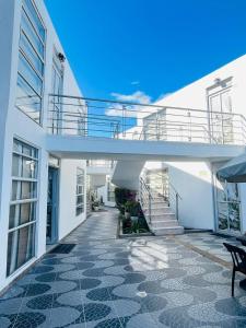 a white house with a staircase and a balcony at Zuruma Hotel in Leticia