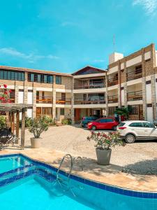 a hotel with a swimming pool in front of a building at Falésia Praia Hotel in Canoa Quebrada