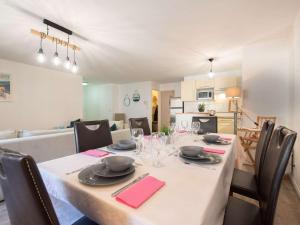 einen Esstisch mit einem weißen Tischtuch und Stühlen in der Unterkunft Appartement 6 pers. Saint Lary - Centre, Garage, WiFi - FR-1-296-361 in Saint-Lary-Soulan